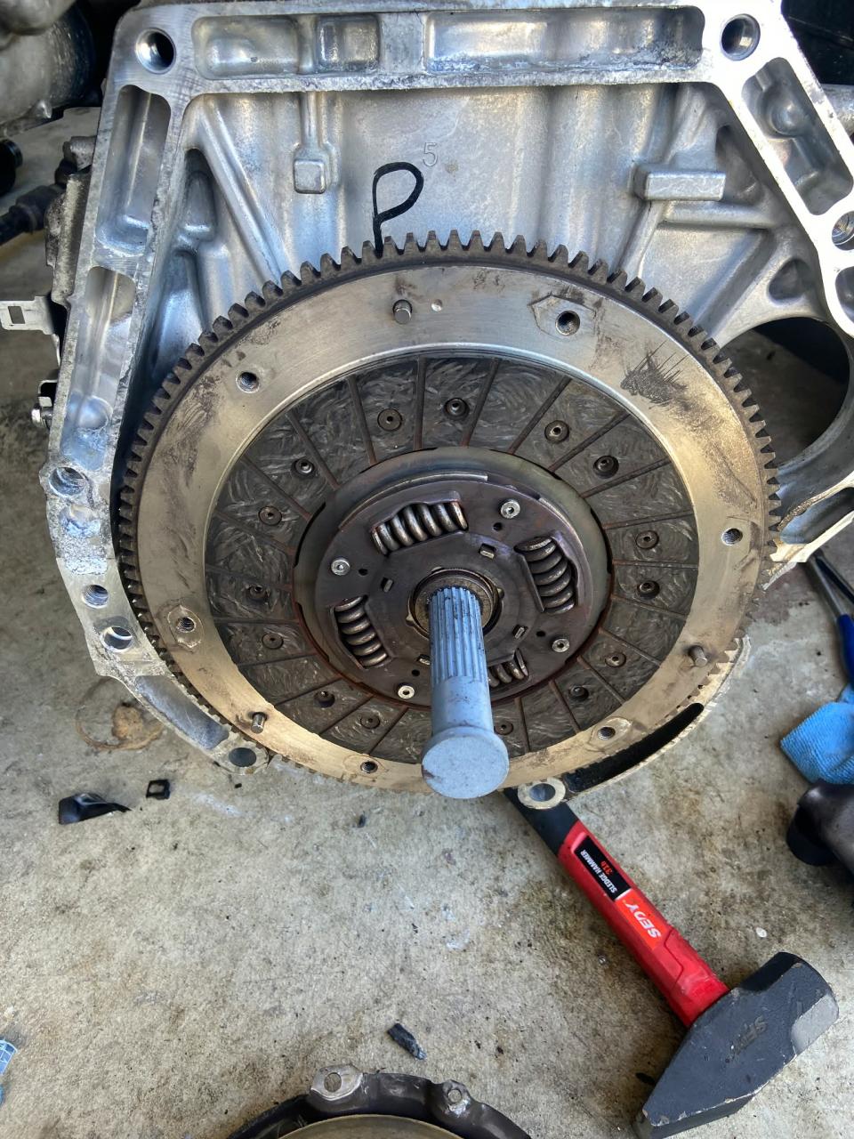 Blue FDM-printed alignment tool inserted through the clutch disc during an actual repair